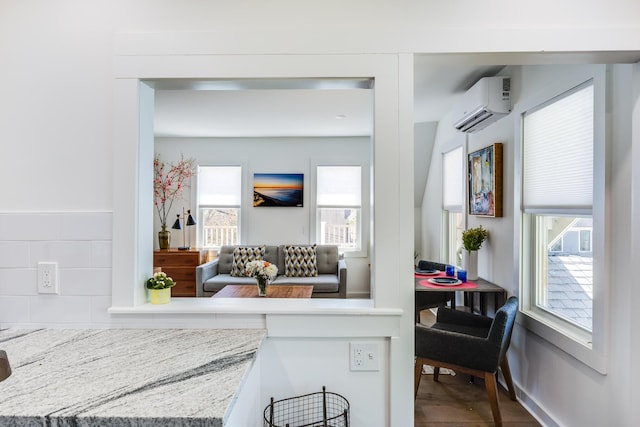 36 Pearl St Unit 2, Provincetown, MA 02657 - kitchen featuring a wall unit AC, wood finished floors, and light stone countertops