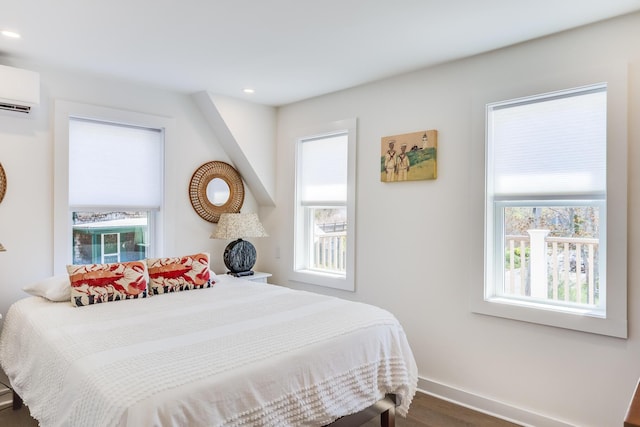 36 Pearl St Unit 2, Provincetown, MA 02657 - bedroom featuring an AC wall unit, multiple windows, wood finished floors, and recessed lighting