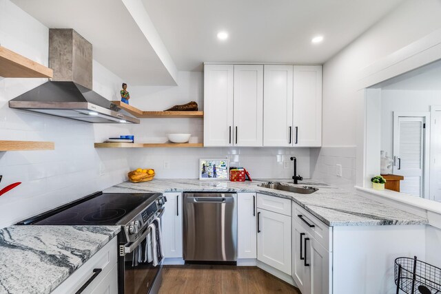 36 Pearl St Unit 2, Provincetown, MA 02657 - kitchen featuring wall chimney range hood, a sink, appliances with stainless steel finishes, white cabinetry, and decorative backsplash