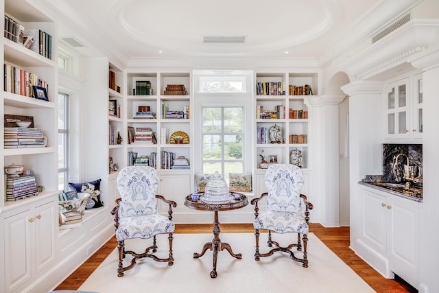 391 Sea View Ave, Osterville, MA 02655 - sitting room featuring dark wood-style floors, crown molding, arched walkways, and built in shelves