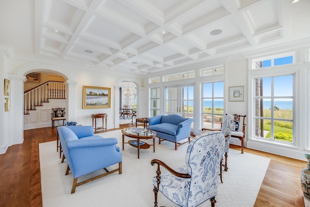 391 Sea View Ave, Osterville, MA 02655 - living area featuring arched walkways, stairway, wood finished floors, beamed ceiling, and coffered ceiling