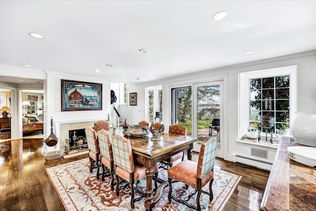 dining space with a baseboard radiator, ornamental molding, wood finished floors, and recessed lighting