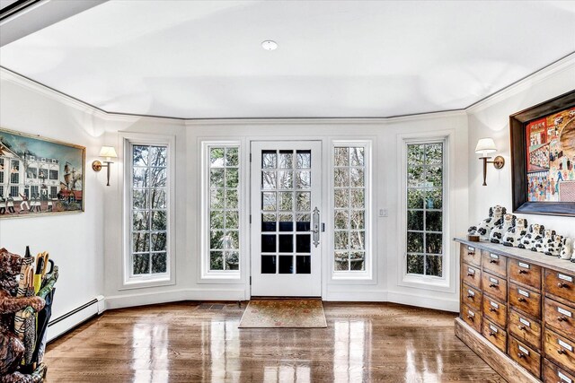 entryway featuring baseboard heating, ornamental molding, wood finished floors, and baseboards