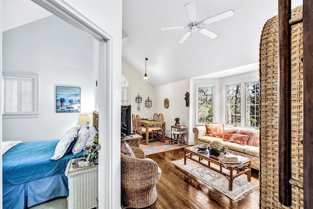 living area featuring wood finished floors, healthy amount of natural light, ceiling fan, and high vaulted ceiling