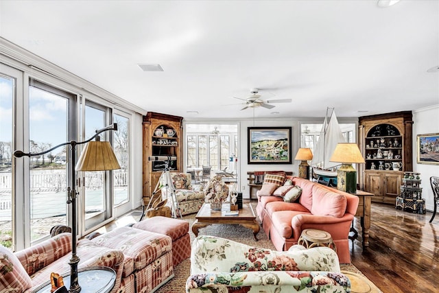 living area featuring wood finished floors, a ceiling fan, ornamental molding, and built in shelves