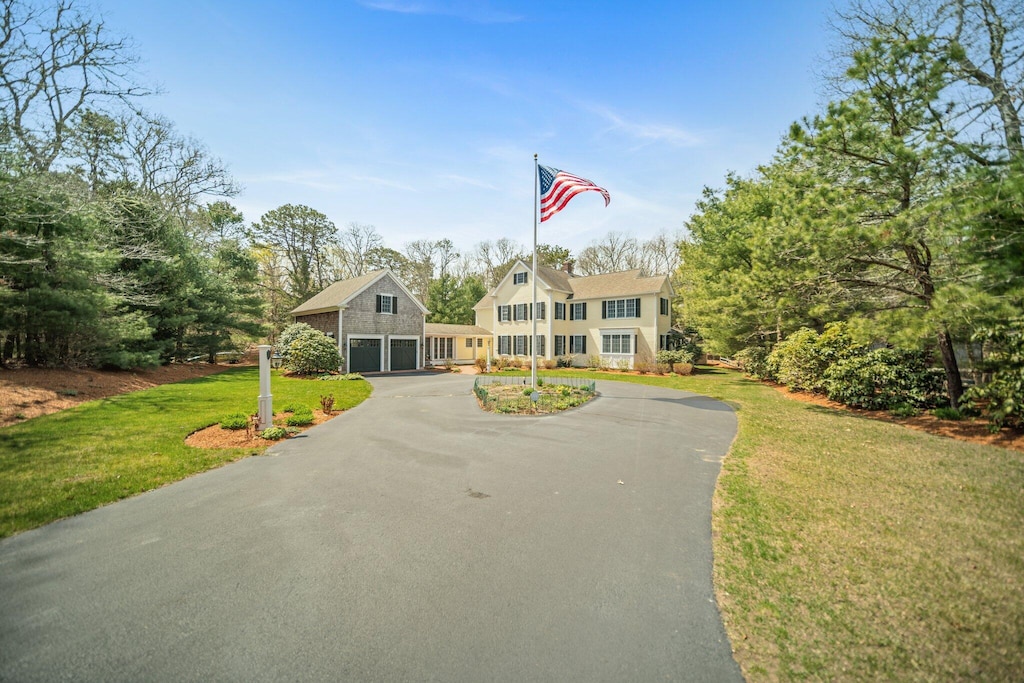 13 Snow Ln, South Dennis, MA 02660 - colonial inspired home with a garage, driveway, and a front lawn