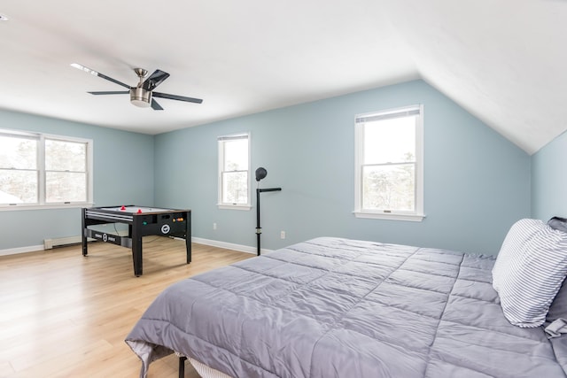 bedroom with vaulted ceiling, ceiling fan, light hardwood / wood-style floors, and a baseboard radiator