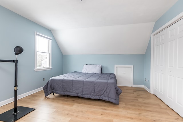 bedroom featuring a closet, lofted ceiling, and light hardwood / wood-style flooring