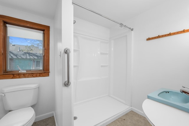 full bathroom featuring a shower stall, a sink, baseboards, and toilet