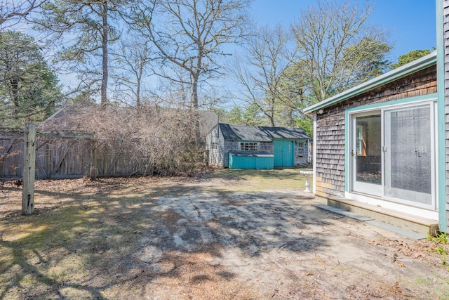 view of yard featuring an outdoor structure, fence, and a storage unit