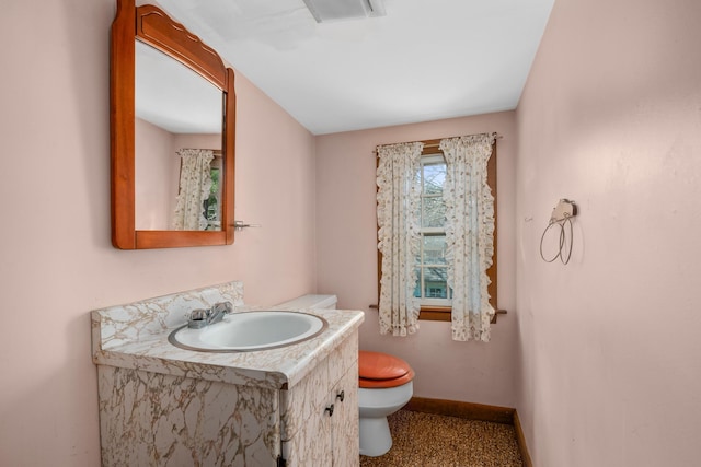 bathroom with vanity, baseboards, visible vents, and toilet