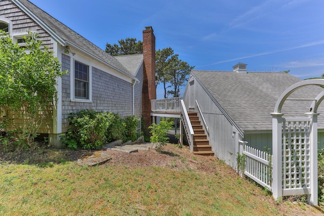 view of home's exterior with a deck and a lawn