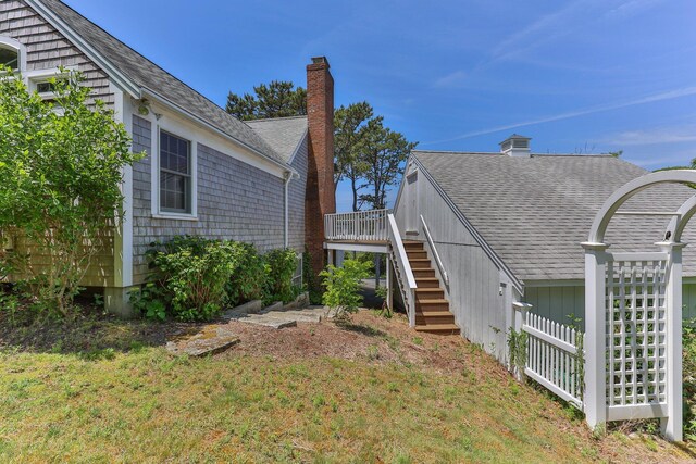 view of home's exterior with a deck and a lawn