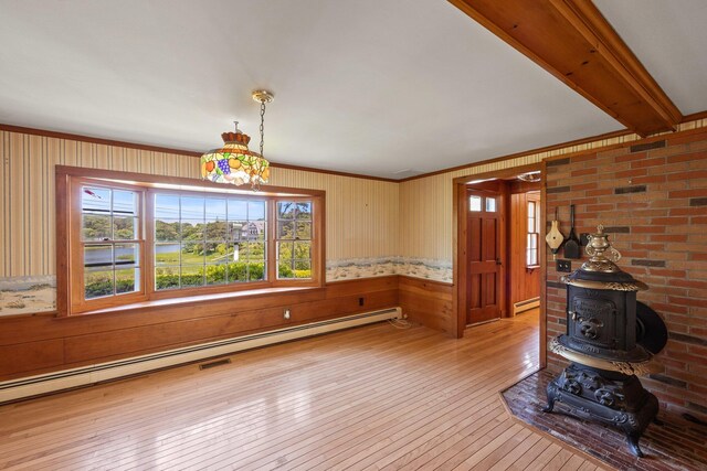 unfurnished living room featuring a wood stove, a baseboard heating unit, and light hardwood / wood-style flooring