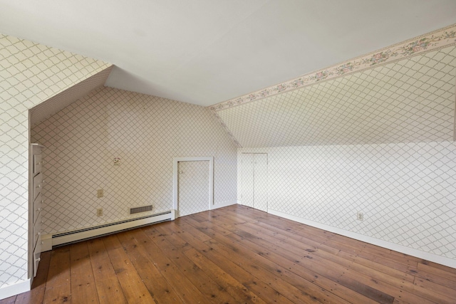 additional living space featuring vaulted ceiling, dark hardwood / wood-style floors, and baseboard heating