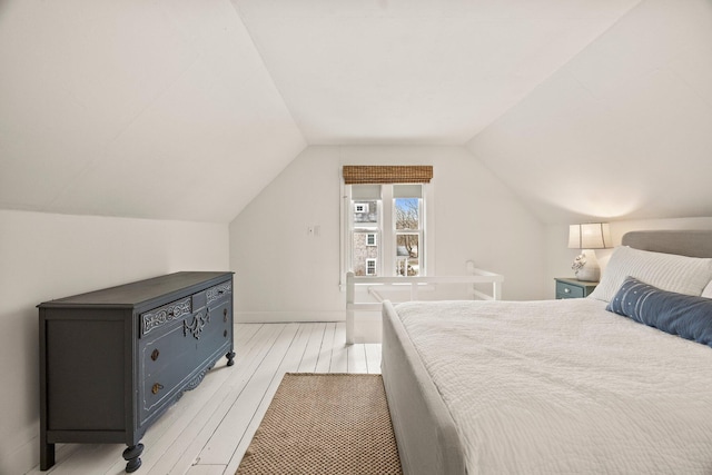 bedroom with lofted ceiling and light hardwood / wood-style flooring