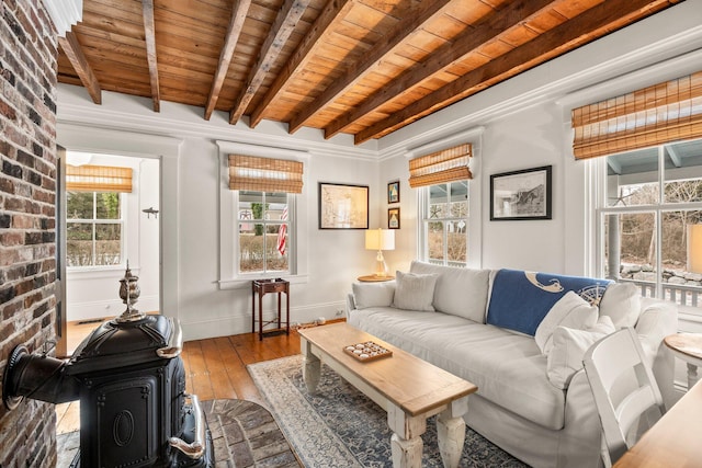 living room featuring wood ceiling, a wood stove, beamed ceiling, and light wood-type flooring