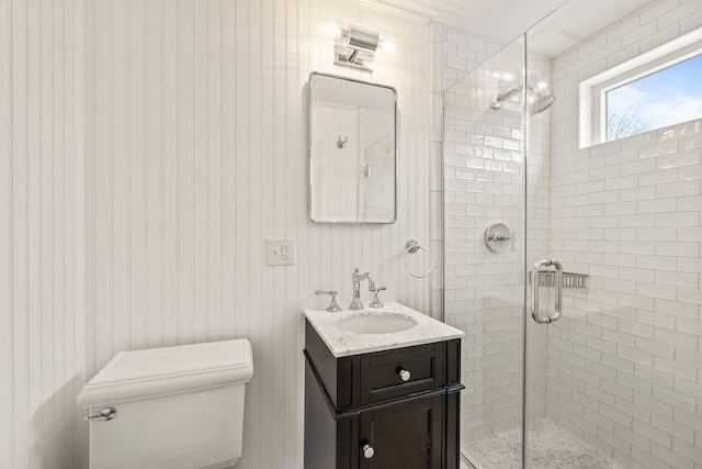 bathroom with walk in shower, vanity, and toilet