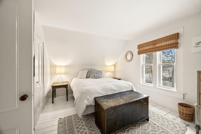 bedroom featuring vaulted ceiling and wood-type flooring