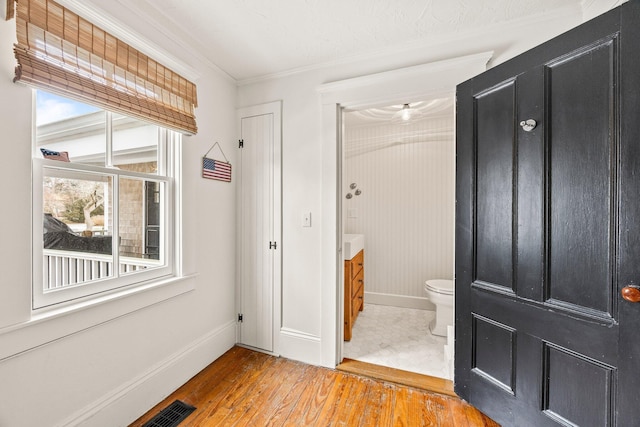 bathroom with vanity, hardwood / wood-style floors, crown molding, and toilet