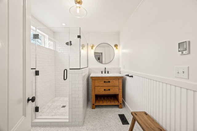 bathroom with an enclosed shower, vanity, crown molding, and tile patterned floors