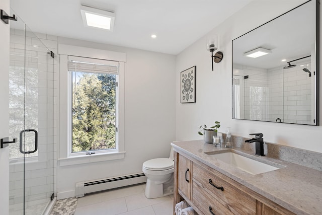 bathroom featuring a baseboard heating unit, a healthy amount of sunlight, a stall shower, and vanity