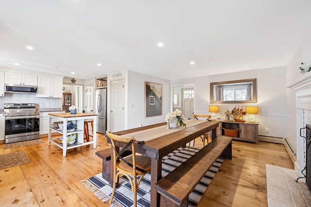 dining space with recessed lighting and light wood-type flooring