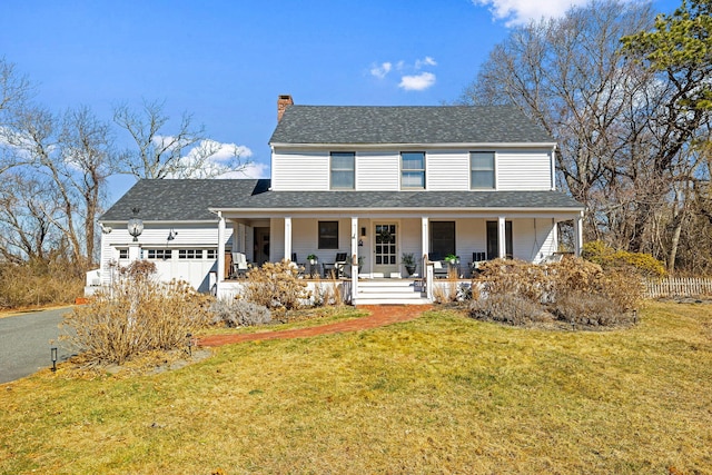 view of front of home with a front yard, covered porch, a shingled roof, a chimney, and a garage