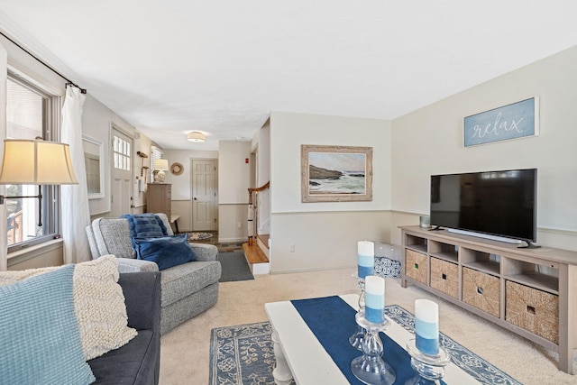 carpeted living room featuring stairs