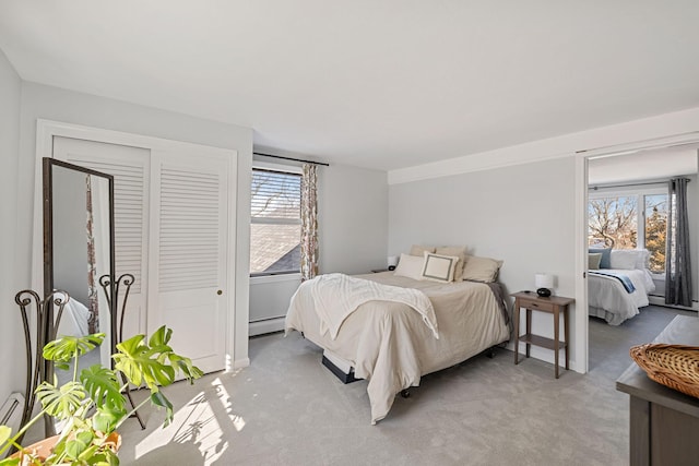 bedroom with a baseboard heating unit, multiple windows, and light carpet