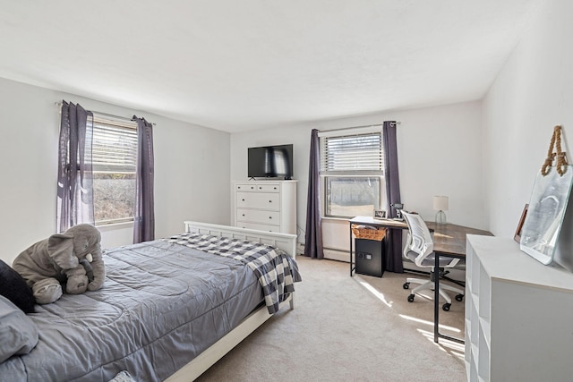 bedroom with baseboard heating, multiple windows, and light colored carpet