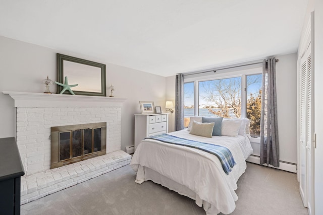 carpeted bedroom featuring a baseboard radiator, a brick fireplace, and a baseboard heating unit