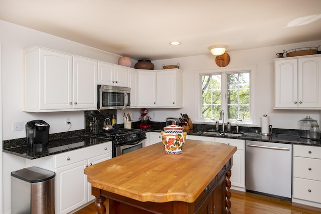2181 Service Rd, West Barnstable, MA 02668 - kitchen featuring appliances with stainless steel finishes, a sink, white cabinetry, dark stone counters, and recessed lighting