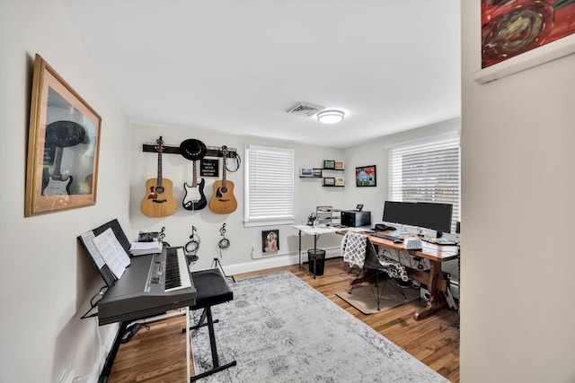 office featuring visible vents, baseboards, and wood finished floors