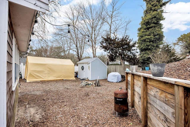 view of yard with an outdoor structure, a storage unit, and fence