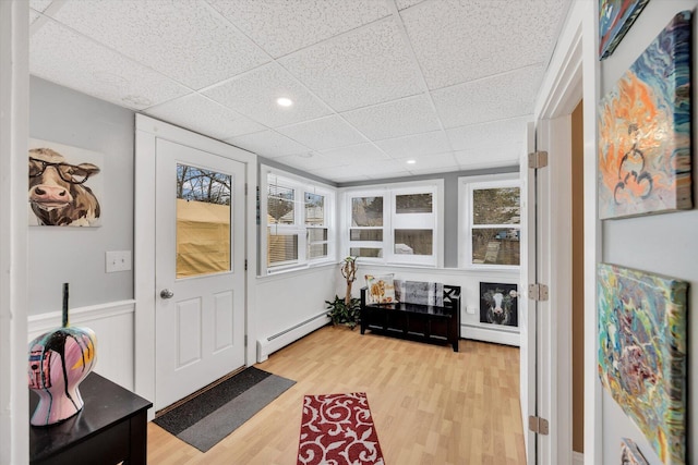 sunroom / solarium with plenty of natural light, a baseboard heating unit, and a baseboard radiator