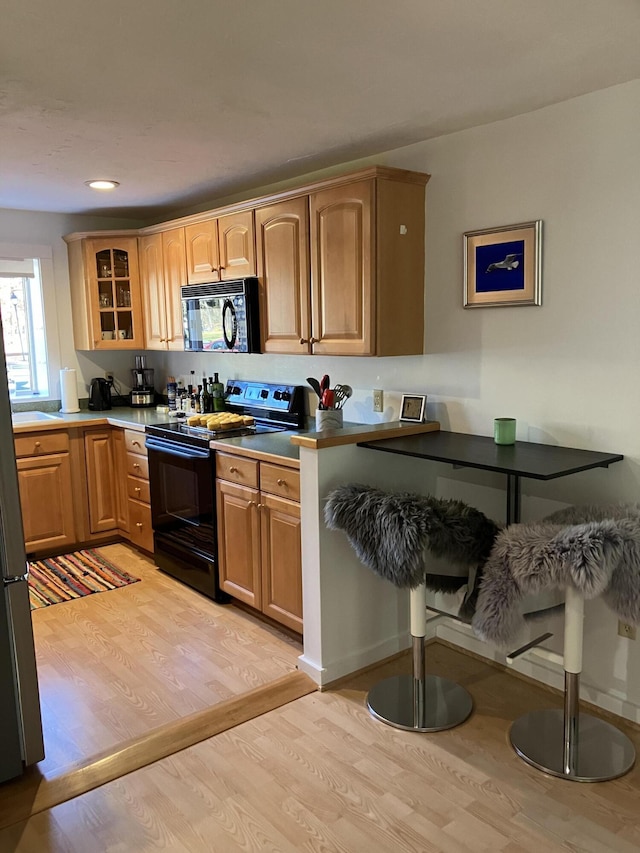 kitchen featuring light hardwood / wood-style floors and black appliances