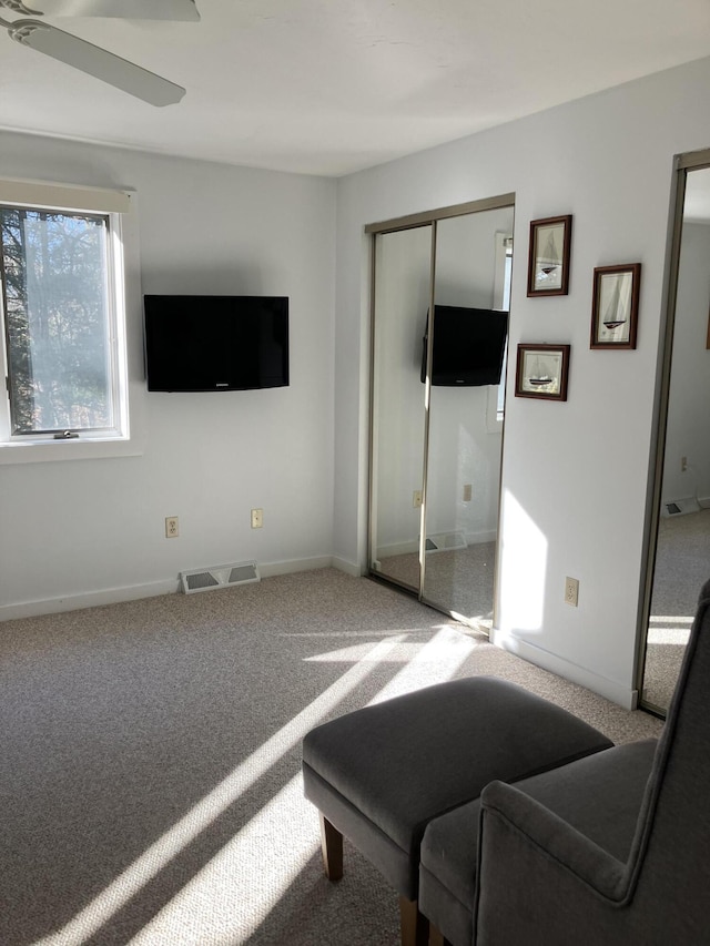 carpeted living room featuring ceiling fan