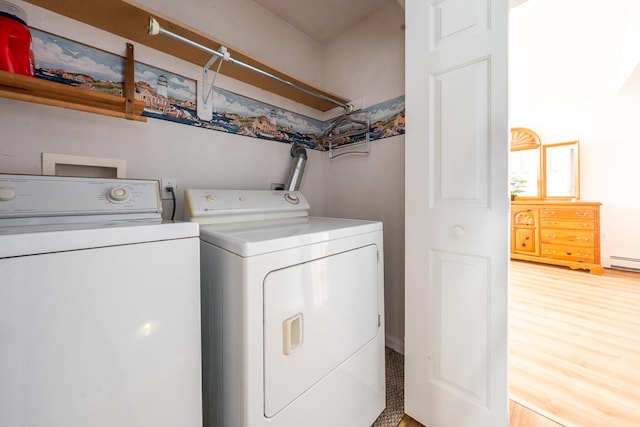 clothes washing area with light wood-style floors, separate washer and dryer, and laundry area