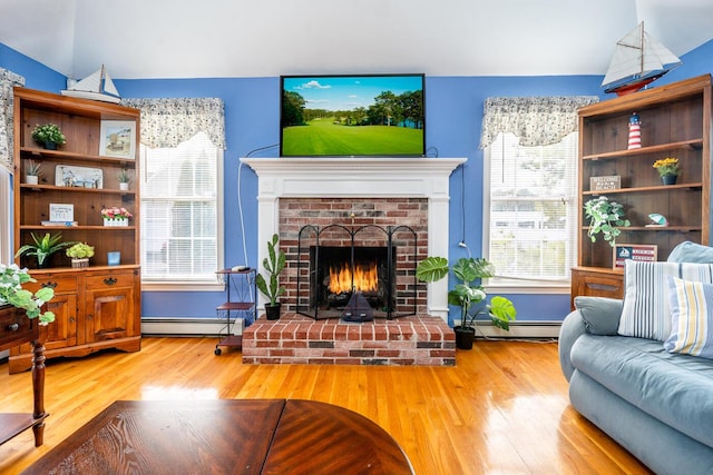 living area featuring wood finished floors, a fireplace, and a baseboard radiator