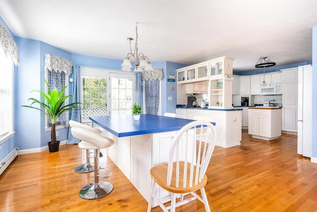 kitchen with open shelves, light wood-style floors, white microwave, and a center island