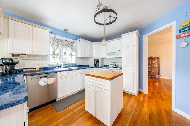 kitchen featuring white microwave, wooden counters, dishwasher, range with electric stovetop, and a sink