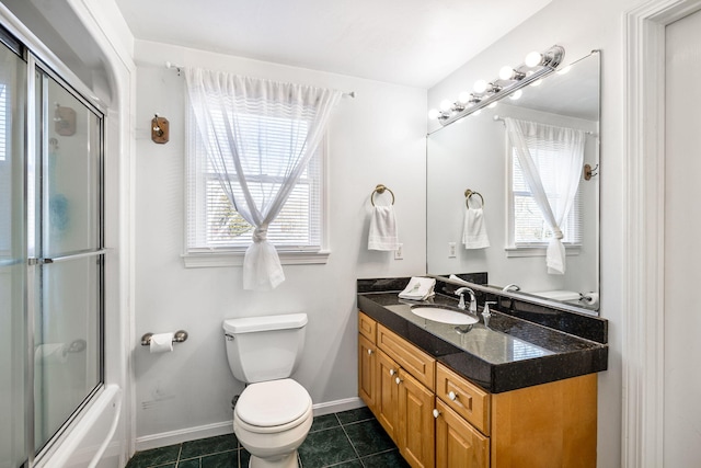 bathroom with toilet, shower / bath combination with glass door, vanity, baseboards, and tile patterned floors