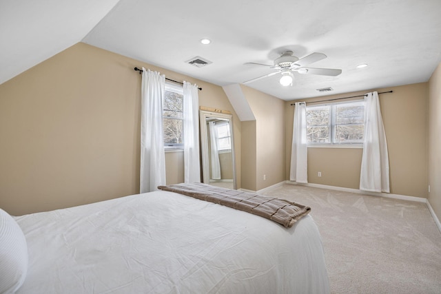 bedroom featuring visible vents, baseboards, light colored carpet, lofted ceiling, and ceiling fan