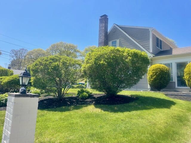 2 Spinning Brook Rd, South Yarmouth, MA 02664 - view of home's exterior with a chimney and a lawn