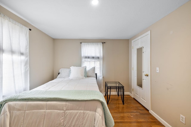 bedroom with baseboards and wood finished floors