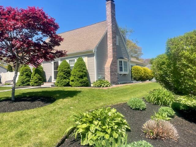 2 Spinning Brook Rd, South Yarmouth, MA 02664 - view of home's exterior with a chimney and a yard