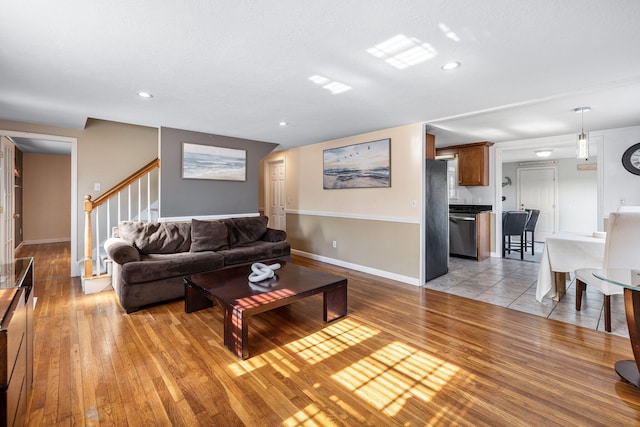 living area featuring light wood finished floors, stairway, recessed lighting, and baseboards