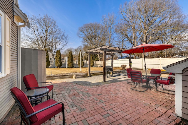 view of patio with an outbuilding, a fenced backyard, and a pergola