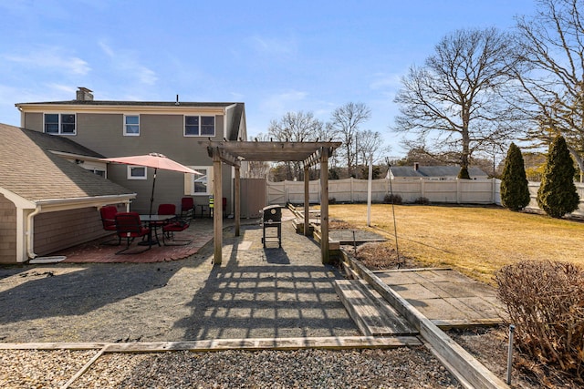 exterior space with a chimney, a patio area, a pergola, a yard, and a fenced backyard